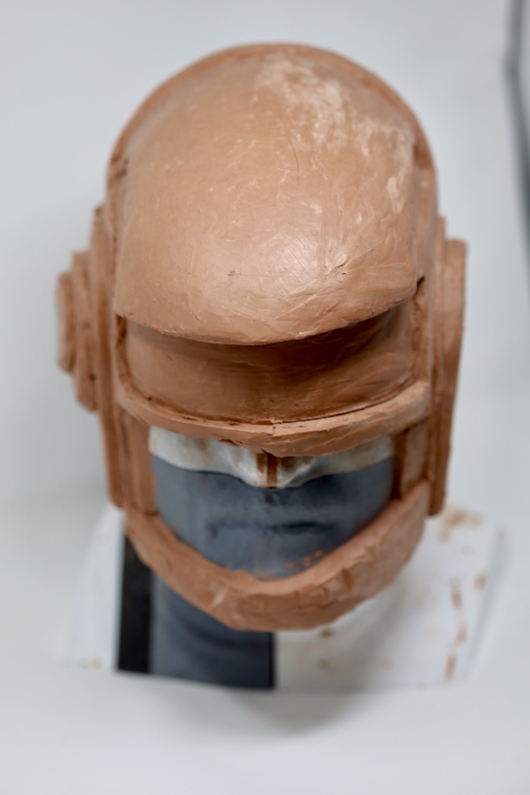 Front view of the clay Daft Punk helmet sculpt on a 3D printed head form
