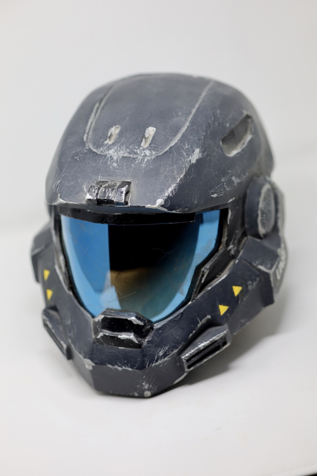 Front view of the weathered Dawn Under Heaven Reach-style helmet prop with a blue visor