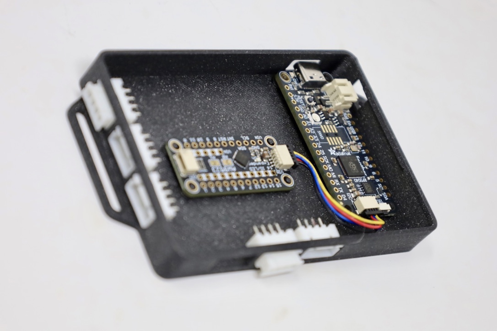 Microcontroller boards and connectors arranged in a 3D printed electronics enclosure