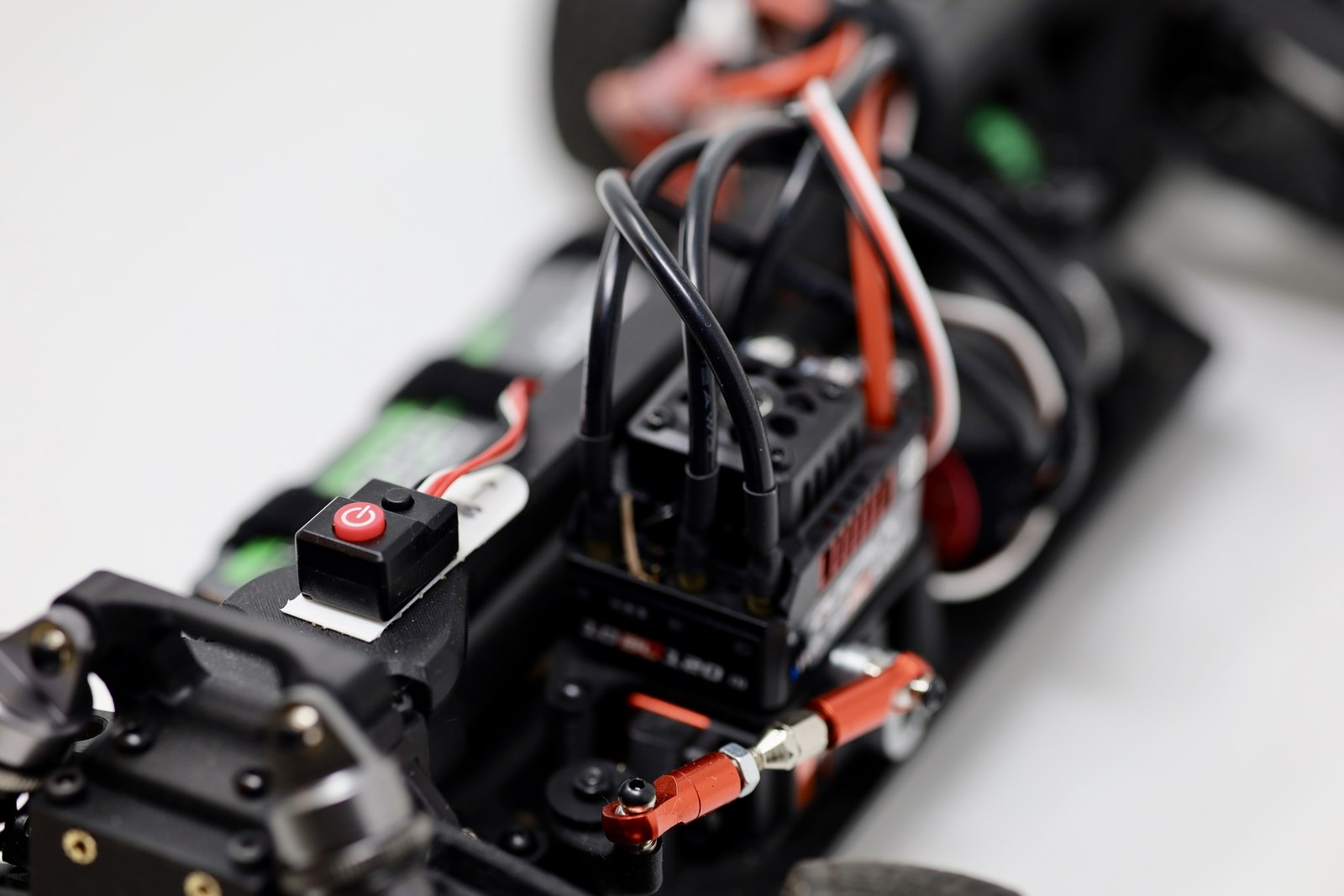 Close-up of the RC car electronics, wiring, and power switch