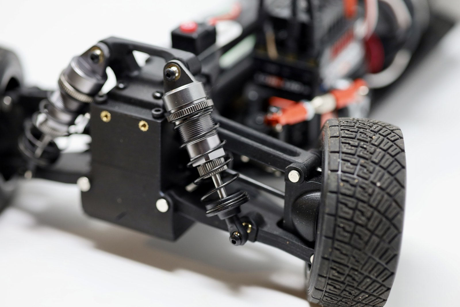 Close-up of the RC car shock, tire, and suspension arm